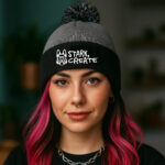 Charcoal and black pom pom beanie with fold-over cuff, embroidered Stark Create logo, and soft ribbed knit design